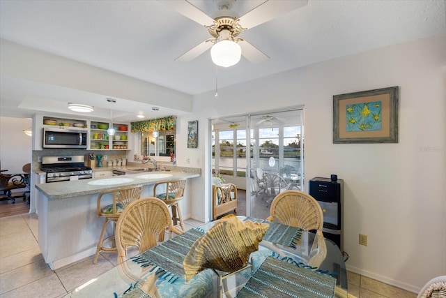 interior space featuring light tile patterned floors, ceiling fan, and sink