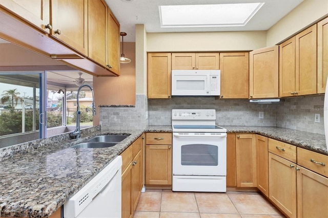 kitchen with backsplash, white appliances, sink, and dark stone counters