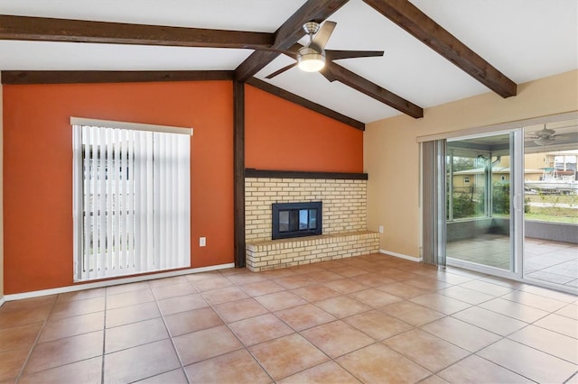 unfurnished living room with ceiling fan, light tile patterned flooring, lofted ceiling with beams, and a brick fireplace