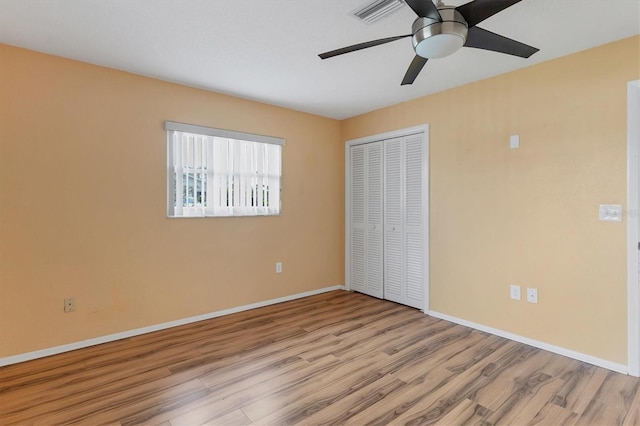 unfurnished bedroom with ceiling fan, light hardwood / wood-style flooring, and a closet