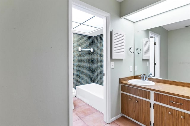 bathroom with tiled shower, vanity, tile patterned floors, and toilet