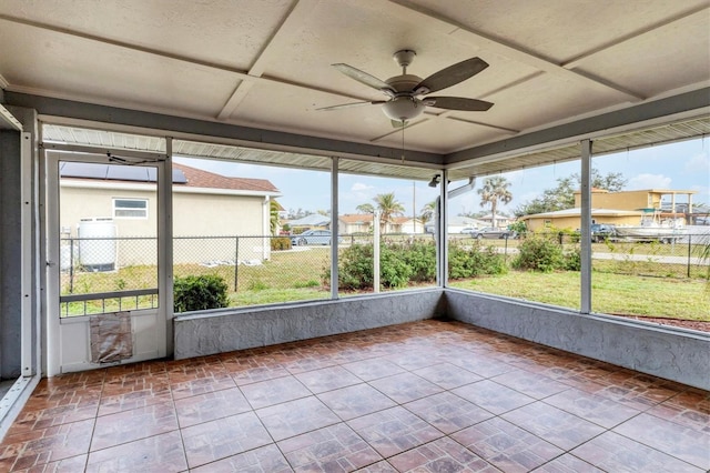 unfurnished sunroom featuring ceiling fan and coffered ceiling