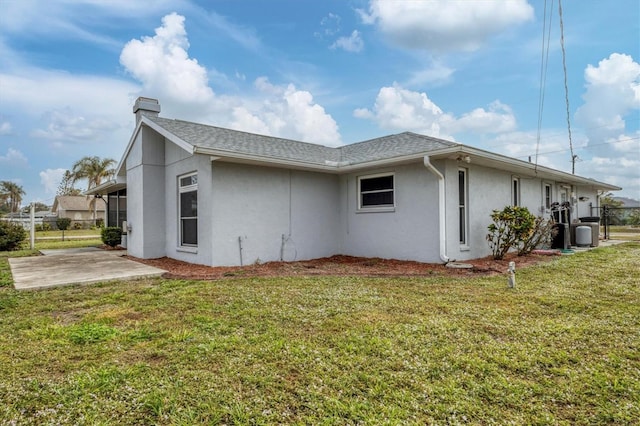 view of side of property with a lawn and a patio