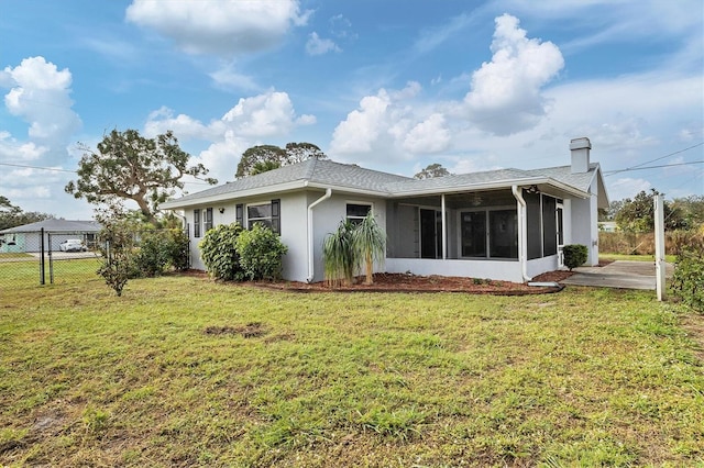 rear view of property with a yard and a sunroom