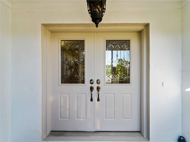 doorway to property featuring french doors and stucco siding