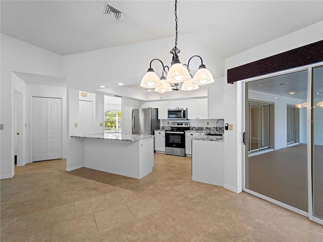 kitchen featuring visible vents, appliances with stainless steel finishes, white cabinets, light stone countertops, and a peninsula