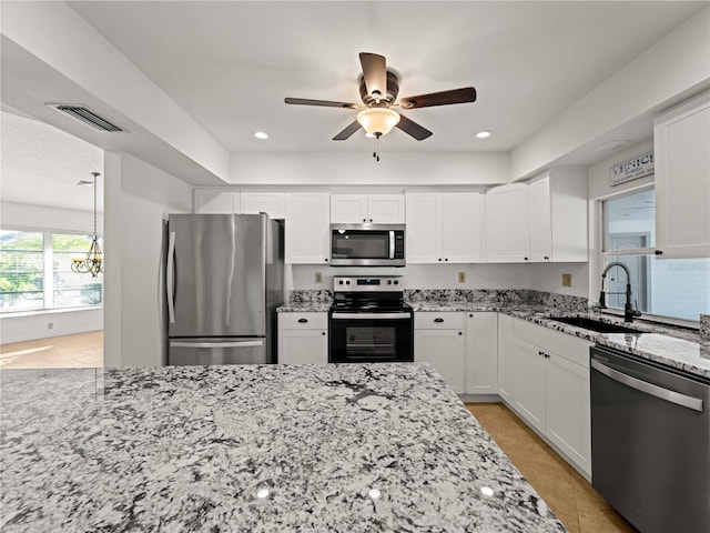 kitchen featuring white cabinetry, visible vents, appliances with stainless steel finishes, and light stone counters