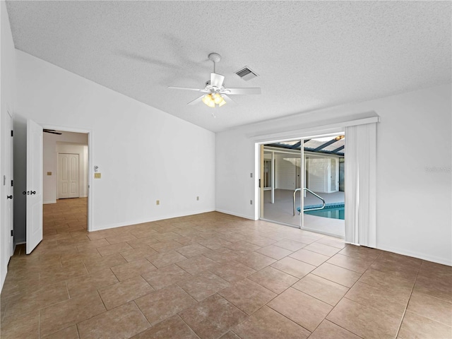 empty room with baseboards, visible vents, ceiling fan, vaulted ceiling, and a textured ceiling