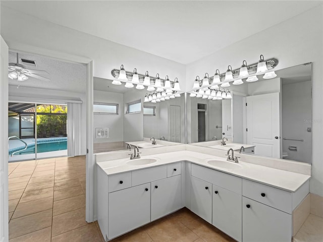 bathroom with ceiling fan, tile patterned flooring, a sink, and double vanity