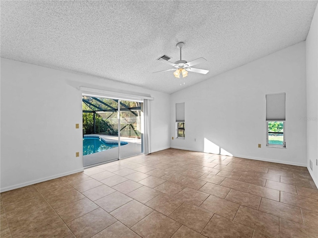 tiled empty room with a ceiling fan, lofted ceiling, visible vents, and plenty of natural light