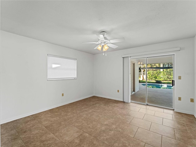 empty room featuring light tile patterned floors, ceiling fan, and baseboards