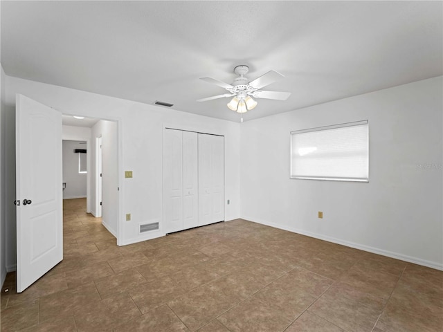 unfurnished bedroom featuring a ceiling fan, a closet, visible vents, and baseboards