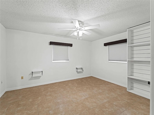 unfurnished room with a textured ceiling, a ceiling fan, and baseboards