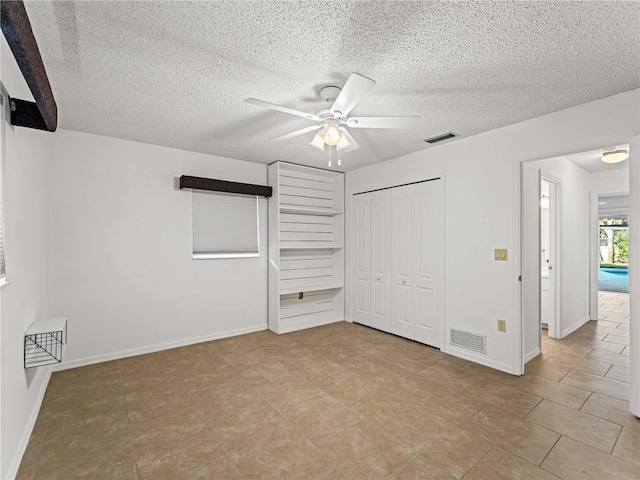 unfurnished bedroom featuring a closet, visible vents, a textured ceiling, and baseboards