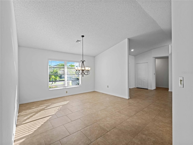 tiled spare room featuring a chandelier, lofted ceiling, visible vents, and baseboards