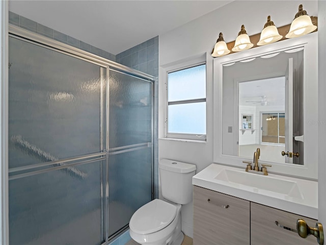 bathroom featuring a shower stall, toilet, and vanity