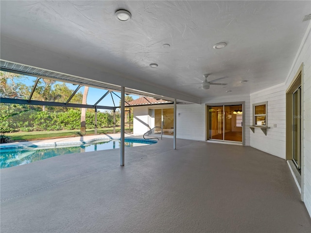 pool featuring ceiling fan, glass enclosure, and a patio