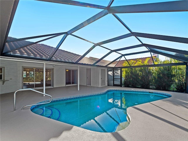 pool featuring glass enclosure and a patio