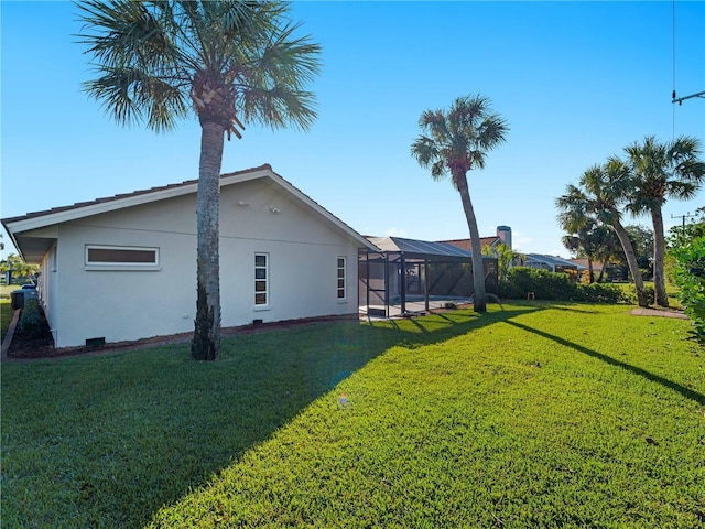 view of property exterior featuring a lawn, a lanai, and stucco siding