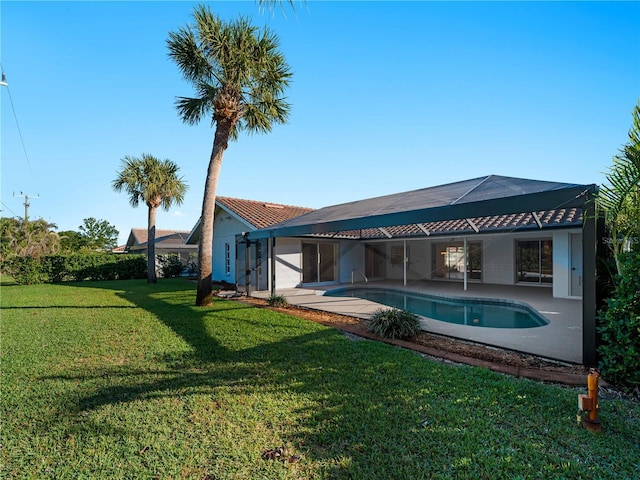 rear view of house featuring glass enclosure, a yard, an outdoor pool, and a patio