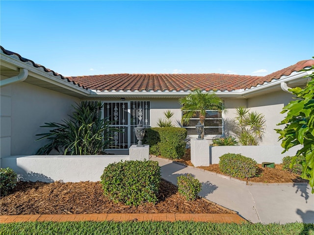 view of front of house with a tiled roof and stucco siding