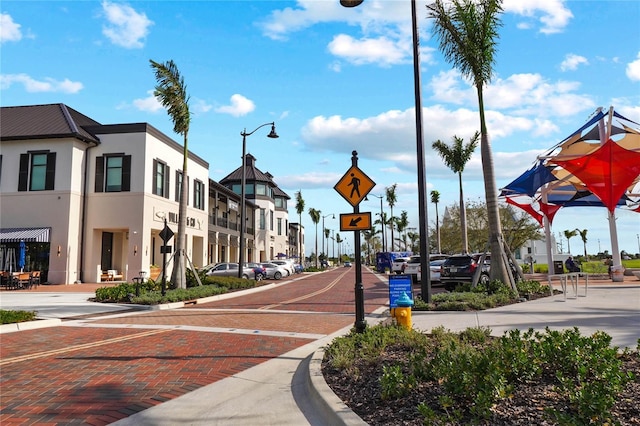 view of street featuring curbs, street lighting, traffic signs, and sidewalks