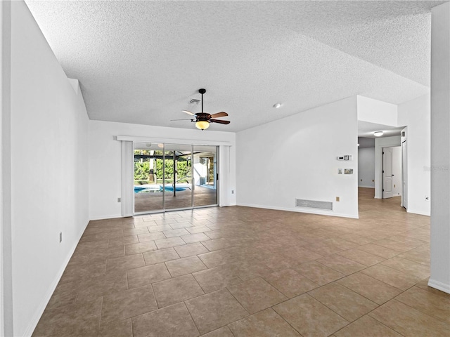 tiled spare room with ceiling fan, a textured ceiling, visible vents, baseboards, and vaulted ceiling