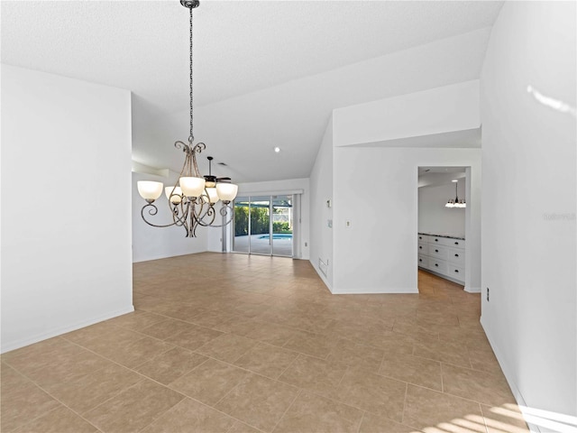 spare room featuring a chandelier, lofted ceiling, and baseboards