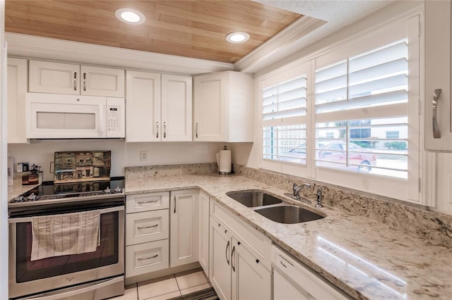 kitchen featuring stainless steel range oven, white cabinetry, sink, and a tray ceiling