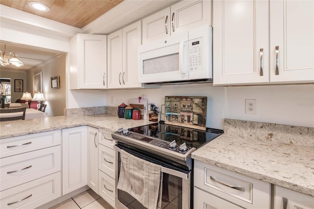 kitchen with light stone countertops, electric stove, light tile patterned floors, an inviting chandelier, and white cabinetry