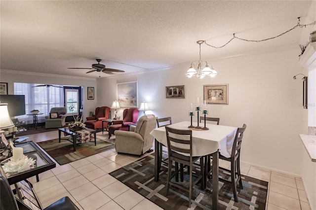 tiled dining area with a textured ceiling, ceiling fan with notable chandelier, and crown molding