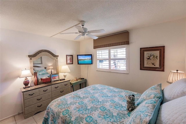 tiled bedroom featuring ceiling fan and a textured ceiling