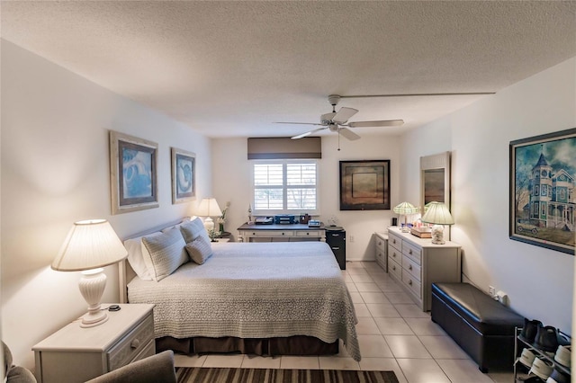 tiled bedroom with ceiling fan and a textured ceiling