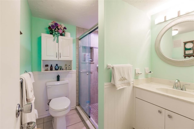 bathroom with vanity, tile patterned floors, toilet, a textured ceiling, and a shower with shower door