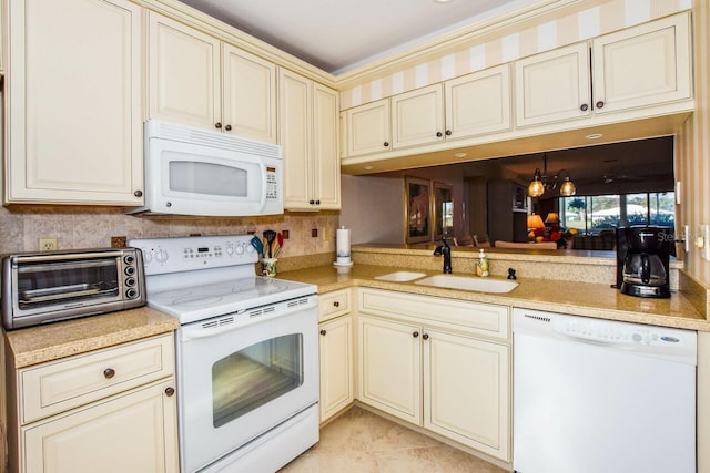 kitchen featuring white appliances, sink, cream cabinets, a notable chandelier, and light tile patterned flooring