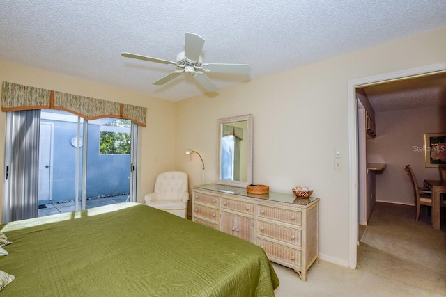 carpeted bedroom with ceiling fan, access to exterior, and a textured ceiling