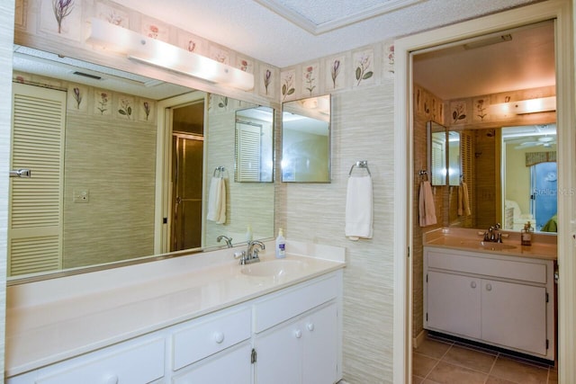 bathroom featuring tile patterned flooring, vanity, and a textured ceiling