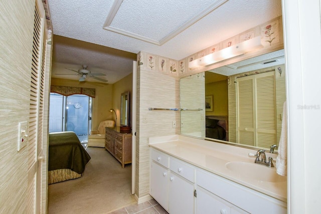 bathroom featuring ceiling fan, tile patterned flooring, vanity, and a textured ceiling