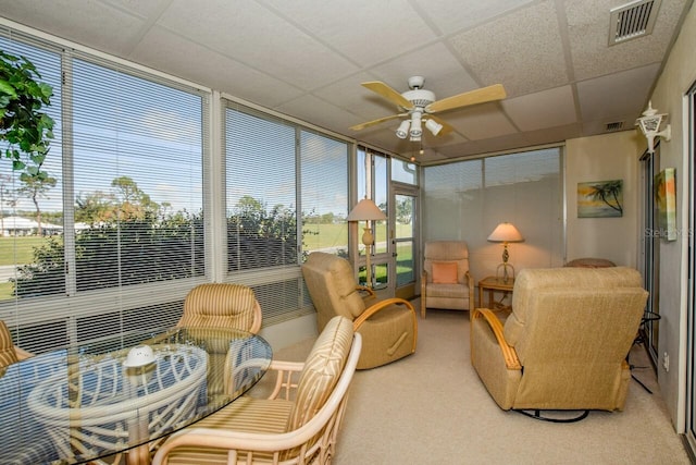 sunroom / solarium with a drop ceiling and ceiling fan