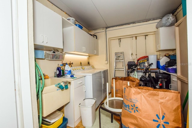 laundry room featuring cabinets, independent washer and dryer, and sink