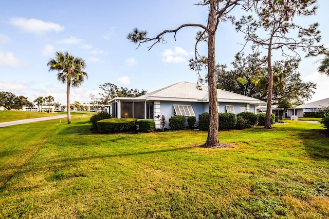 view of front facade with a front lawn and a sunroom