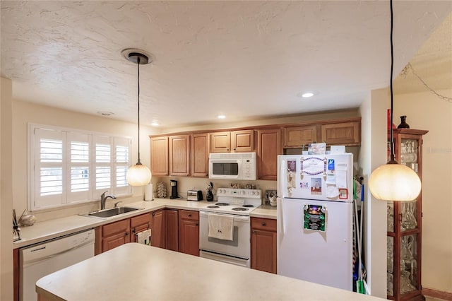 kitchen with sink, decorative light fixtures, and white appliances