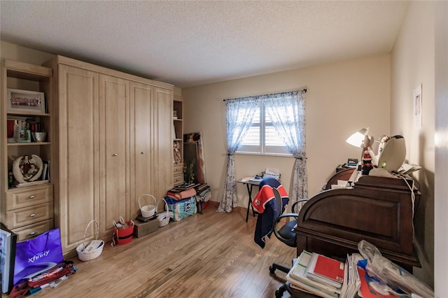 interior space featuring a textured ceiling and light hardwood / wood-style floors