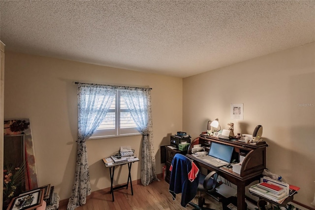 home office with wood-type flooring and a textured ceiling