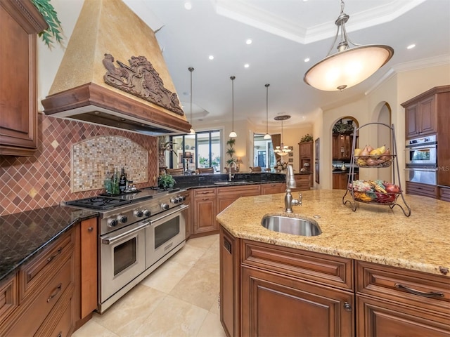 kitchen with light stone countertops, sink, crown molding, decorative light fixtures, and appliances with stainless steel finishes