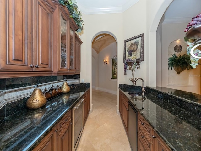 bar featuring sink, tasteful backsplash, dark stone countertops, light tile patterned floors, and ornamental molding