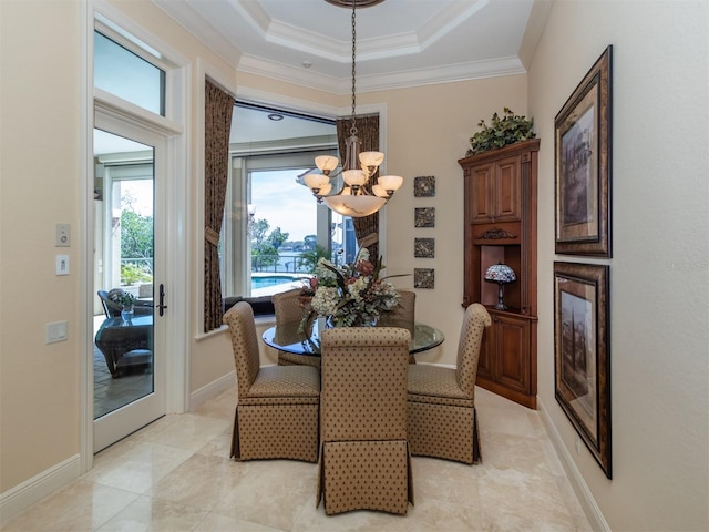 dining area with a raised ceiling, ornamental molding, and an inviting chandelier