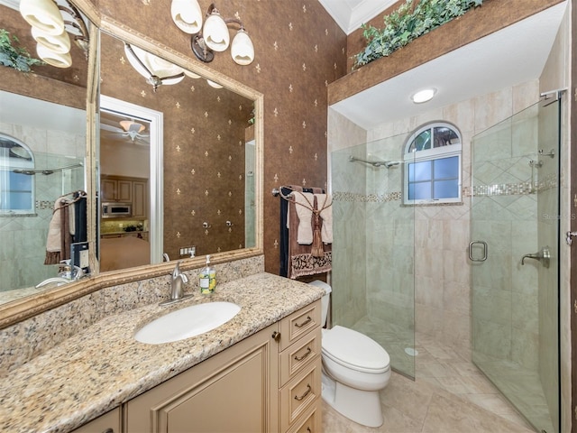 bathroom with an enclosed shower, vanity, ceiling fan, and toilet