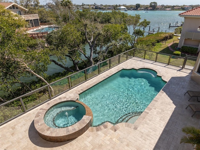 view of pool with an in ground hot tub, a water view, and a patio