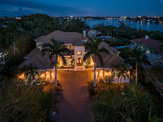 aerial view at dusk featuring a water view